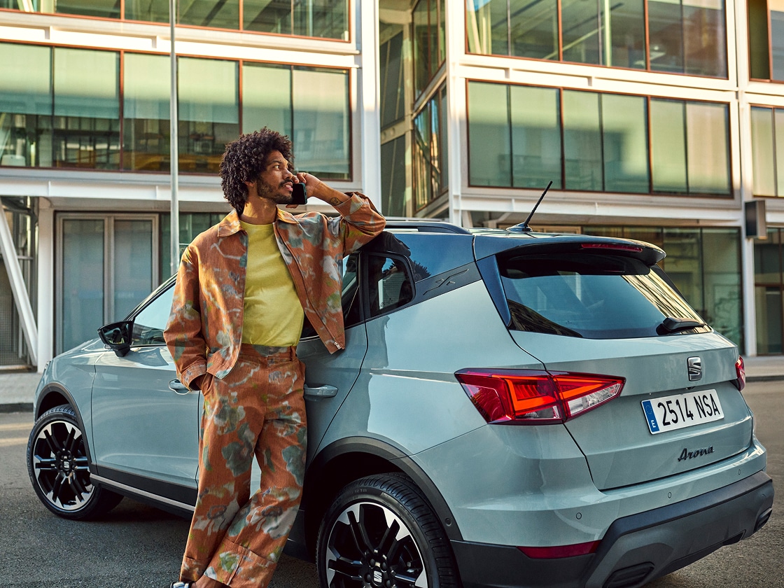 Meitene rokās tur viedtālruni un izmanto SEAT attālinātās funkcijas