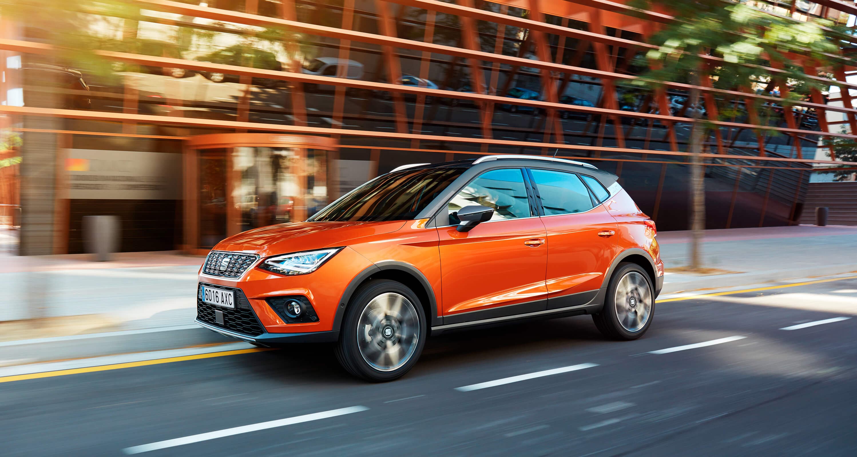 orange eclipse krāsas SEAT Arona eksterjera dizains ārpus telpu sānskats pilsētā