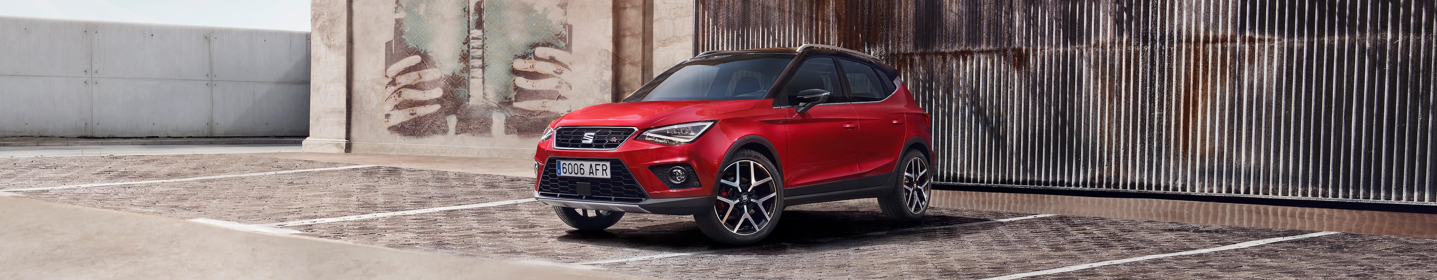 desire red krāsas SEAT Arona pie dabas sānskats no leņķa