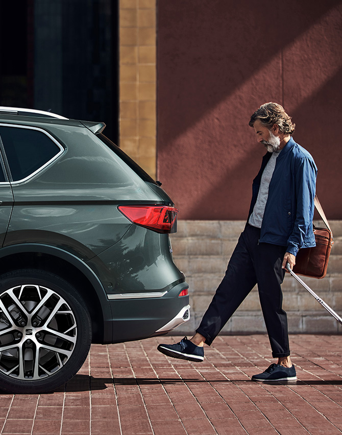 Man beside the SEAT Tarraco XPERIENCE with alloy wheels