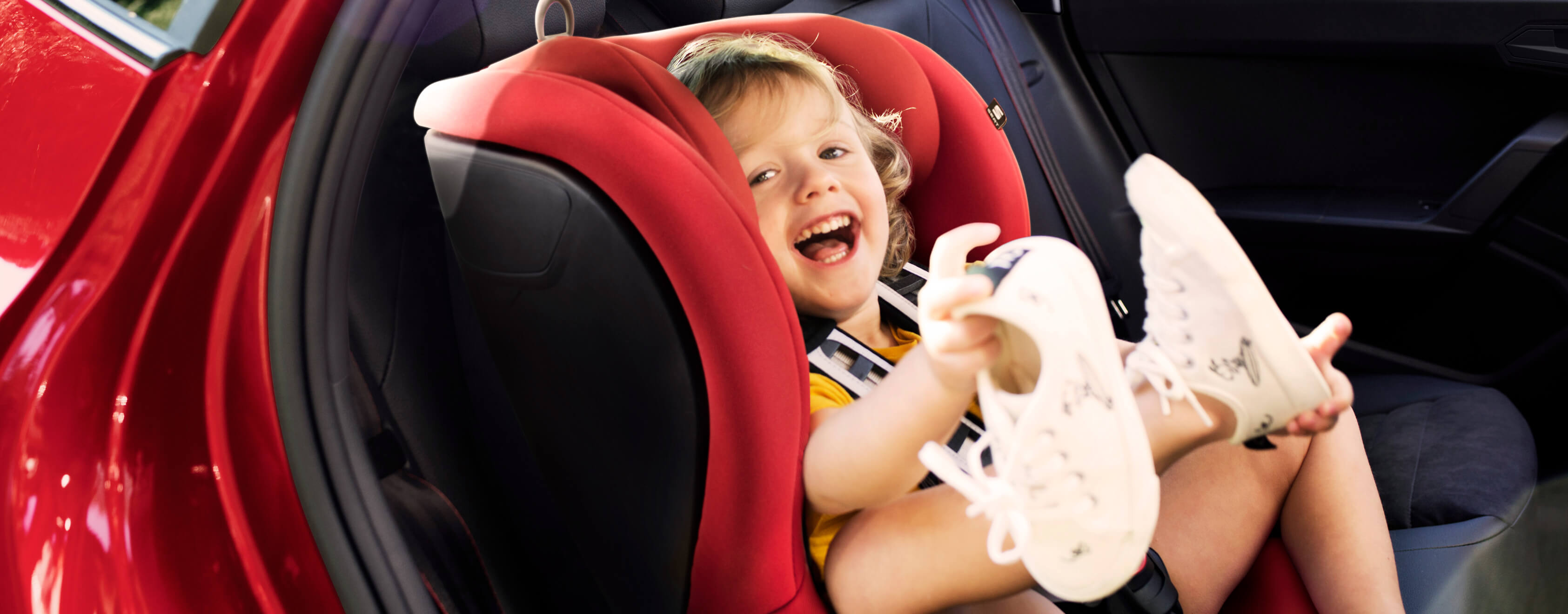 SEAT jauno auto serviss –smaidīgs bērns sēž automašīnas aizmugurē