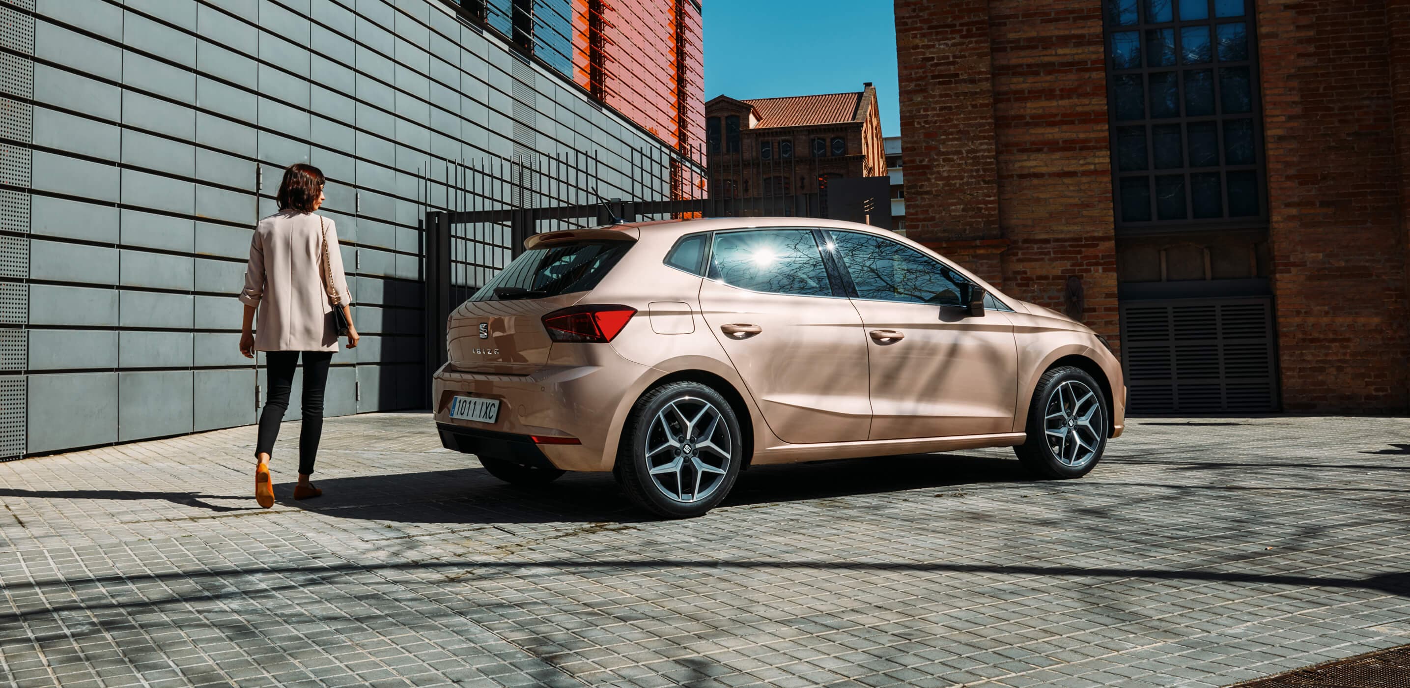 SEAT car servicing and maintenance accident specialists safety – woman standing beside a parked SEAT Ibiza hatchback city car