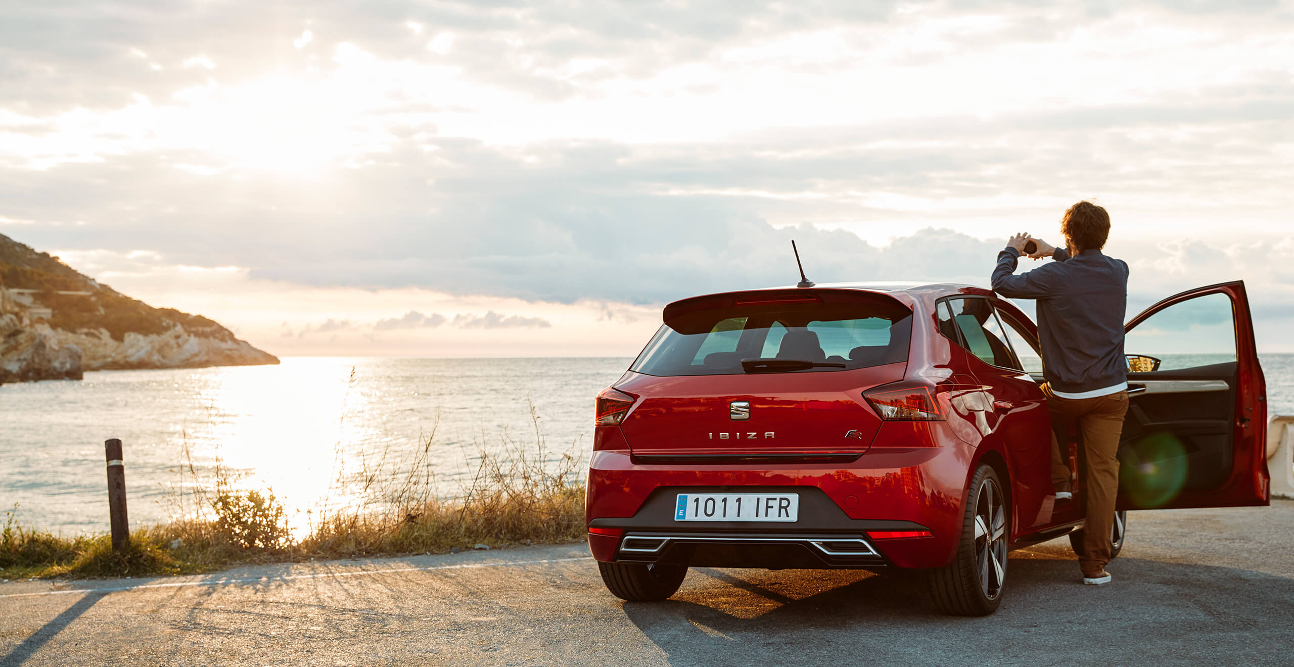 SEAT new car services roadside assistance maintenance – SEAT Ibiza city car hatchback overlooking the sea with a man taking a photograph